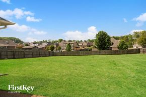 Arlington house for rent - A grassy field with a fence and houses in the background.