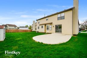 Columbus house for rent - a backyard with green grass and a house with a cement patio