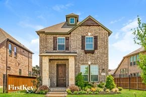 Arlington house for rent - exterior view of a brick home with a wood fence and grass
