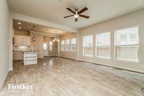 Arlington house for rent - an empty living room with a ceiling fan and a kitchen