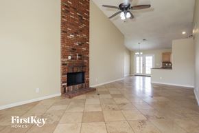 Glendale house for rent - A room with a brick fireplace and a ceiling fan.