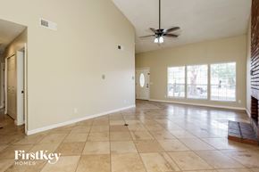 Glendale house for rent - A spacious room with a fan and tile flooring.