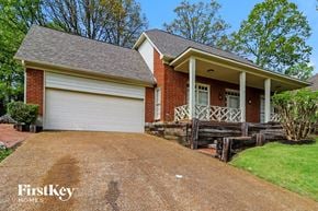 Memphis house for rent - A brick house with a white garage door and a porch.