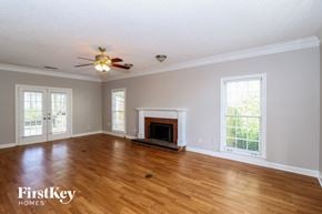 Memphis house for rent - A spacious living room with a fireplace and a ceiling fan.