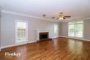 Memphis house for rent - A spacious room with a fireplace and a ceiling fan.