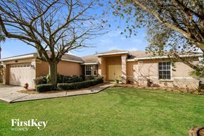Winter Haven house for rent - a beige house with a lawn and a tree