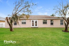 Winter Haven house for rent - a pink house with a lawn and two trees