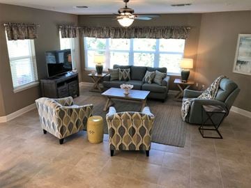Bradenton house for rent - a living room with couches and chairs and a tv