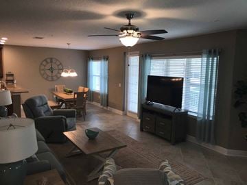 Bradenton house for rent - an open living room and dining room with a large tv