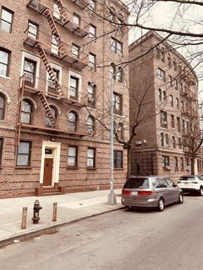 Bronx apartment for rent - a car parked on a street in front of a brick building