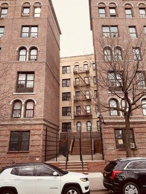 Bronx apartment for rent - a white car parked in front of a tall brick building