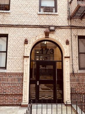 Bronx apartment for rent - the front of a brick building with a glass door