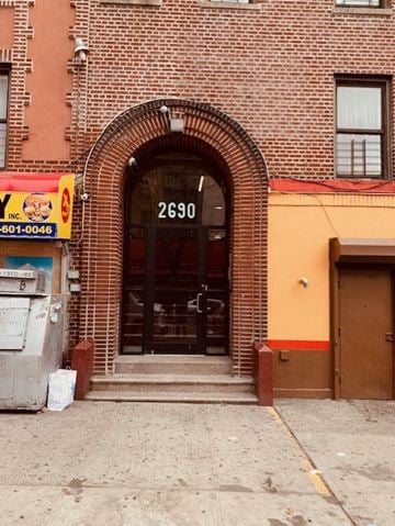 Bronx apartment for rent - the front door of a brick building with a