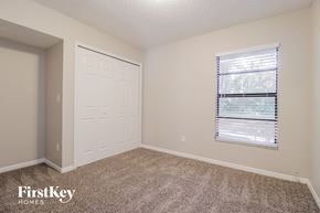 Deltona house for rent - a bedroom with carpet and a door and a window