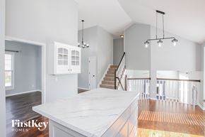 Kansas City house for rent - an open kitchen with a marble counter top and a staircase