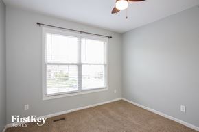 Kansas City house for rent - a bedroom with a large window and a ceiling fan