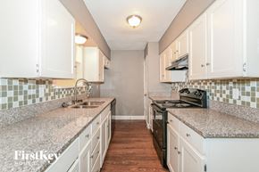 Dallas house for rent - a kitchen with white cabinets and granite counter tops