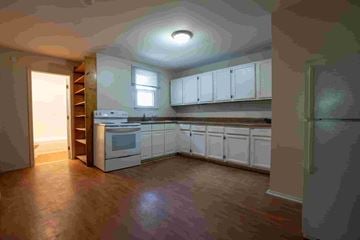 Gambrills apartment for rent - A kitchen with white cabinets and a stove top oven.