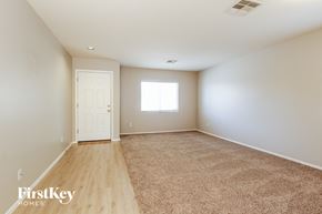 Youngtown house for rent - A room with a carpeted floor and a door leading to another room.