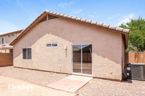 Youngtown house for rent - A house with a brown stucco exterior and a tiled roof.