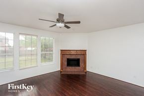 Garland house for rent - a living room with a fireplace and a ceiling fan
