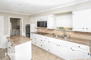 Garland house for rent - a white kitchen with granite counter tops and white cabinets