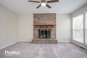 West Chester house for rent - A room with a brick fireplace and a ceiling fan.