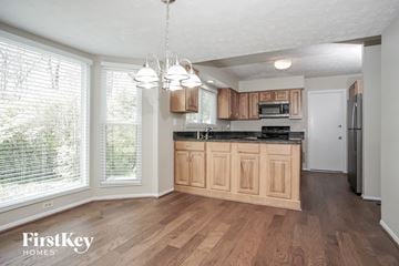 West Chester house for rent - A kitchen with wooden cabinets and a black countertop.