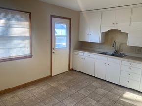 Fremont house for rent - A kitchen with white cabinets and a tiled floor.