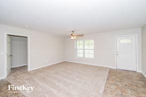 Austell house for rent - a empty living room with a ceiling fan and a door to a closet