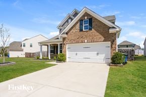 Mount Holly house for rent - a brick house with a white garage door in front of a lawn