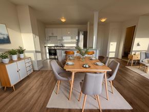 Toronto apartment for rent - A modern dining room with a wooden table and chairs.