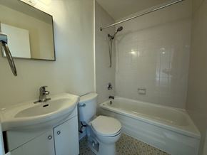 Toronto apartment for rent - A white toilet sits next to a white sink in a bathroom.