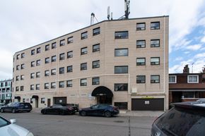 Toronto apartment for rent - A building with a parking lot in front of it.