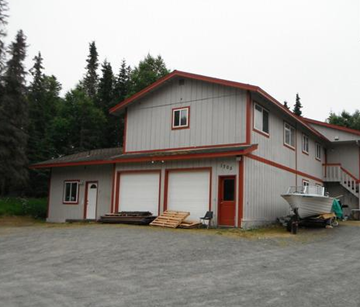 Kenai apartment for rent - a white house with a boat parked outside of it