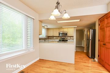 Wildwood house for rent - A kitchen with wooden floors and white appliances.