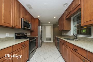 Kissimmee house for rent - A kitchen with wooden cabinets and a FirstKey Homes logo.