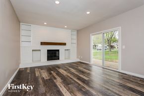 Saint Peters house for rent - A spacious room with a fireplace and wood flooring.