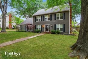 Collierville house for rent - a house with a lawn and trees in front of it