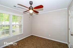 Collierville house for rent - a bedroom with a ceiling fan and a window