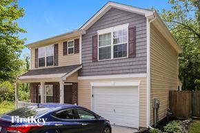Concord house for rent - A blue car is parked in front of a two-story house.