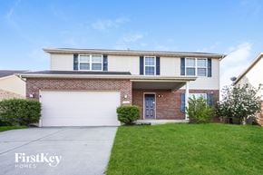 Monroe house for rent - a brick house with a white garage door and a lawn