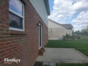 Monroe house for rent - the side of a brick house with a sidewalk and grass