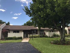 Bradenton house for rent - a house with a yard and a tree in front of it