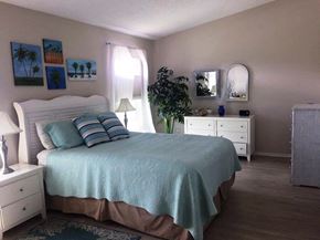 Bradenton house for rent - a bedroom with a bed and a dresser and a mirror