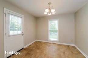 Greensboro house for rent - the dining room of a home with a white door and tiled floors