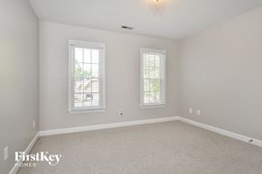 Greensboro house for rent - a bedroom with white carpet and two windows