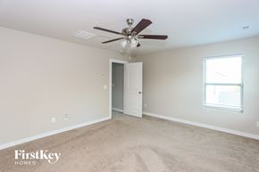 Mooresville house for rent - A spacious room with a ceiling fan and a door leading to another room.