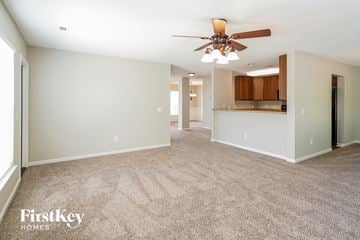 Summerville house for rent - a spacious living room with carpet and a ceiling fan