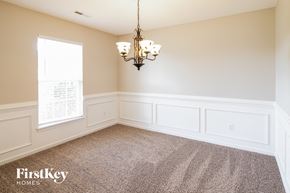Summerville house for rent - an empty dining room with white wainscoting and a chandelier